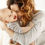 Picture of a smiling christian woman holding a baby