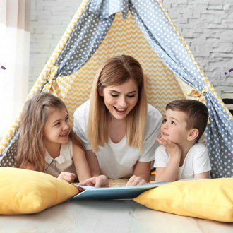 Picture of a christian woman reading to a young boy and girl